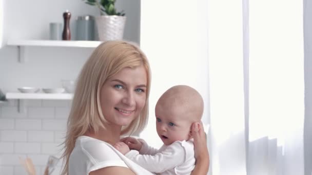 Retrato de la familia feliz en casa, nueva madre abrazos y besos niña recién nacida en la cocina — Vídeos de Stock