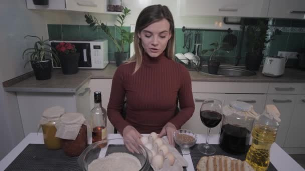 Vlog femenino, joven mujer sonriente atractiva cuenta recetas de vídeo en la cocina en casa para su blog y levanta una copa de vino — Vídeo de stock