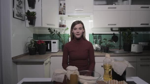 Ama de casa blog, hermosa mujer joven dice receta en directo para el blog y muestra los ingredientes en la cámara — Vídeo de stock