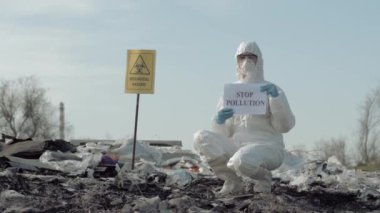 Çevre kirliliği sorunu, koruyucu giysilere dönüşen Tehlikeli Madde İşçileri çöp yığınında biyolojik tehlike içeren kirliliği durdurma işareti gösteriyor