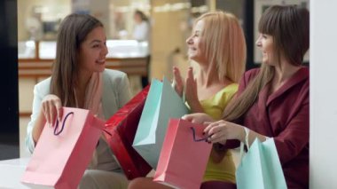 Alışverişte, duygusal şirket kadınlarının moda mağazalarından satış sezonunda yeni alışveriş yapmalarıyla övünmeleri ve Kara Cuma 'da indirimli alışveriş torbaları.
