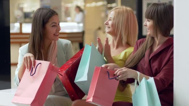 Shopaholism, emotional company female brag about new shopping from fashion stores in season of sales and discounts on black Friday with lot bags — Stock Video