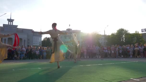 Entretenimiento étnico, grupo de mujeres jóvenes con vestidos tradicionales bailando en el área de la ciudad antes de la multitud pública de vacaciones — Vídeos de Stock