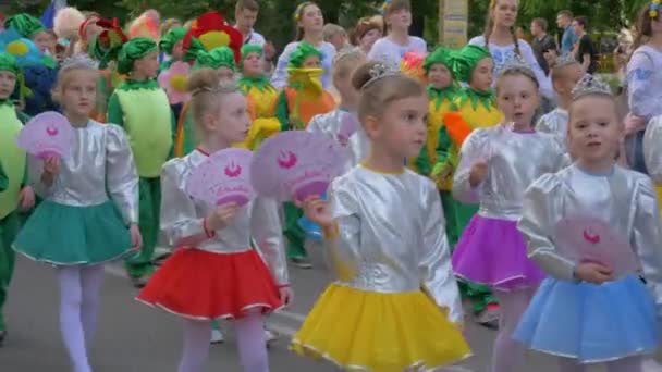 Défilé de fête, foule d'enfants en costumes différents marchent le long de la rue de la ville et crient des chants à l'extérieur — Video