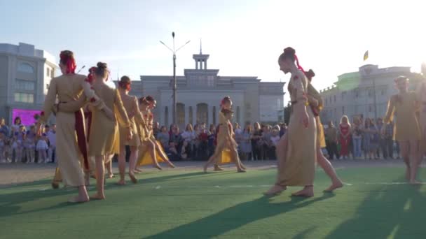 Folklór Fesztivál, fiatal nők csoportja nemzetiségi jelmezben táncol a város főterén a tömeg előtt az emberek nyaralni — Stock videók