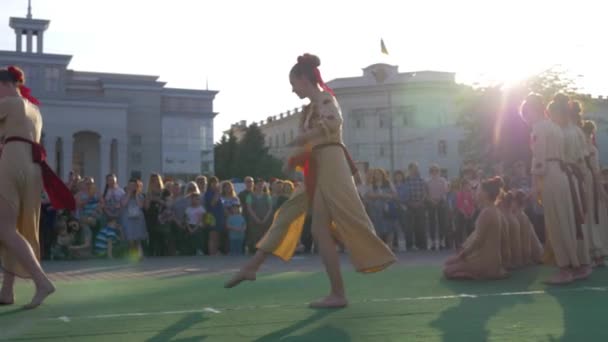 Ulusal şenlikler, geleneksel kostümlü bir grup genç kız kalabalığın önünde sokaklarda dans ediyor. — Stok video