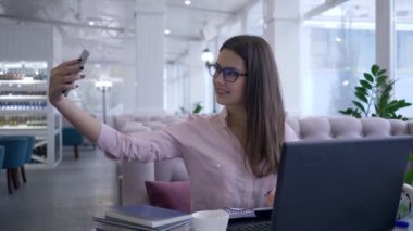 Modern akıllı teknolojiler, mutlu restoran müdürü kadın iş sırasında cep telefonuyla fotoğraf çekti ve not defterine not aldı.