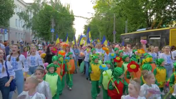 Défilé de spectacles de rue, beaucoup de gens en costumes fantaisie différents marchent le long de la rue de la ville et crient des chants à l'extérieur — Video