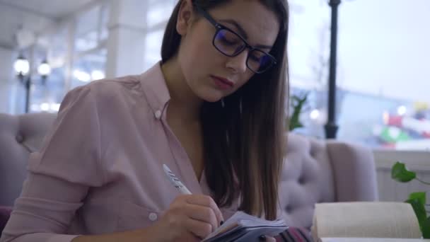 Correspondência estudando, estudante do sexo feminino usa tecnologia laptop moderno para aprender com o ensino on-line e livros fazendo anotações em notebook close-up — Vídeo de Stock