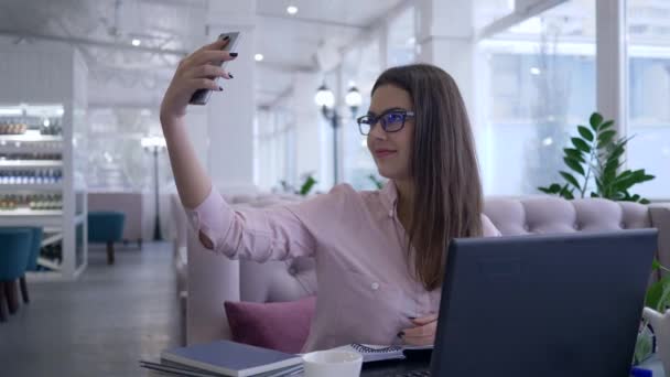 Σύγχρονες έξυπνες τεχνολογίες, ευτυχείς επιτυχημένες γυναίκες φωτογραφήθηκαν στο κινητό τηλέφωνο κατά τη διάρκεια της εργασίας σε φορητό υπολογιστή και κρατά σημειώσεις στο σημειωματάριο — Αρχείο Βίντεο