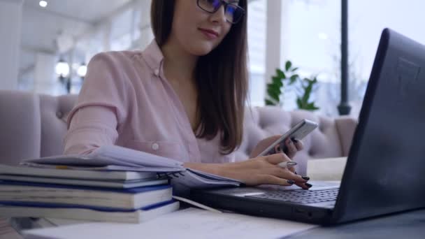 Çevrimiçi iş, başarılı serbest çalışan kadın, modern bilgisayar teknolojisiyle akıllı telefon ve kitapları birleştiriyor. — Stok video