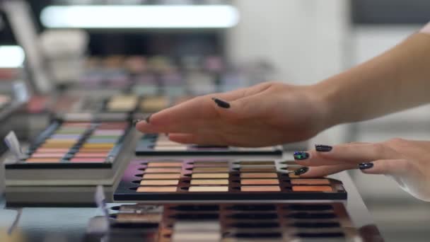 Professionell kosmetika, arm kund flicka väljer ögonskugga från palett av olika färger för professionell make-up och Applicera kosmetika till hands på köpcentret — Stockvideo