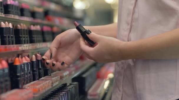 Cosméticos profesionales de las mujeres, chica comprador elige lápiz labial para el maquillaje de la noche y aplicar las pruebas de cosméticos en la mano en el centro comercial — Vídeo de stock
