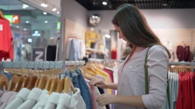 Alışveriş günü, genç mutlu müşteriler alışveriş merkezlerinde indirimler sırasında moda mağazasında yeni şık kıyafetler seçiyor.