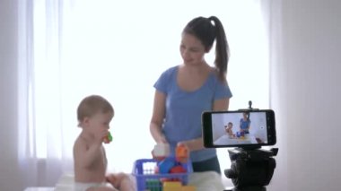 Blog yazarlığı, eğitim oyuncaklarının oynadığı kızla iyi bir çocuk ve sosyal ağlardaki takipçiler için cep telefonundan canlı özel ders videosu.