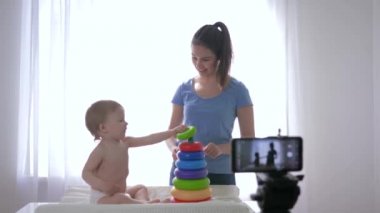 İnternet vlog 'u, anne vlogger' ı olan mutlu çocuk eğitici oyuncakların oynadığı online video blogunu akıllı telefondaki sosyal ağlardaki aboneler için canlı yayınlarken