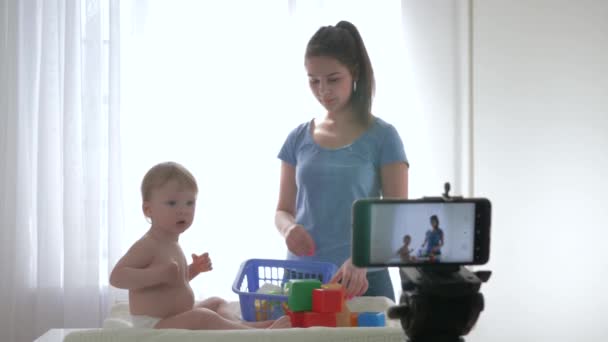 Videoblog streaming live, cute baby boy with mom played by educational toys and filming new episode for vlog in streaming live on smartphone for subscribers in social networks — Stock Video