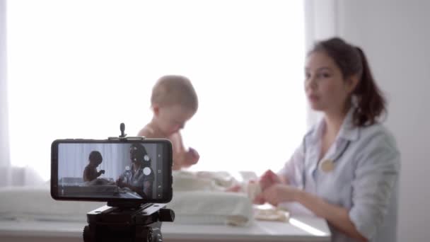 Vlog de Internet, popular vlogger pediatra femenina se alivia a sí mismo en la cámara durante el examen médico del bebé en streaming en vivo — Vídeo de stock