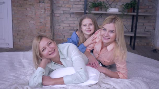 Familie ontspannen thuis, lachen vrouwen met grappige meisjes dochters liggen op bed, terwijl de vrije tijd in de kamer — Stockvideo