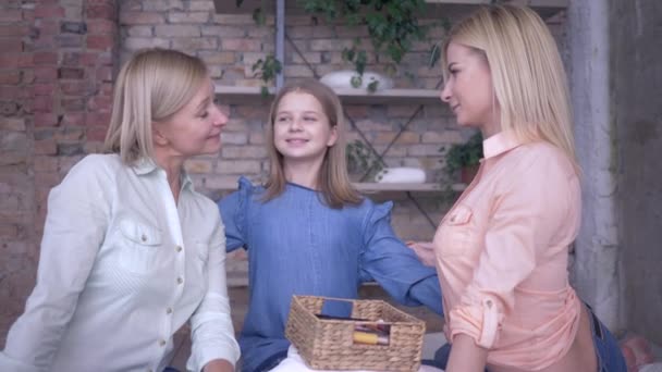 Portrait of loving family, happy mother has fun talking with daughters and hugging while relaxing at home — Stock Video