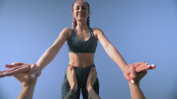 Acro yoga, retrato de chica atlética sonriente con coletas se equilibra en las piernas de su pareja masculina en el fondo del cielo al aire libre — Vídeos de Stock