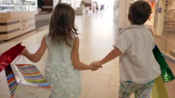 Shoppa barn med många paket i armar kör förbi skyltfönster under inköp på svart fredag — Stockvideo