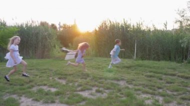 Açık havada çocuk oyunları, aktif mutlu çocuklar arkadaşlar yakalayın ve güneş ışığında yeşil çayırlarda koşun.