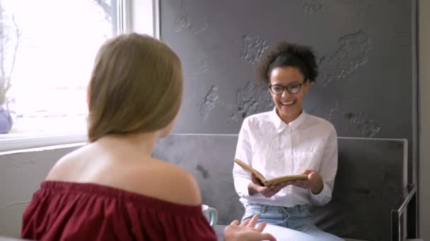 Amizade multi-étnica, alegre menina adolescente negra em óculos se comunica com a namorada e ler livros — Vídeo de Stock