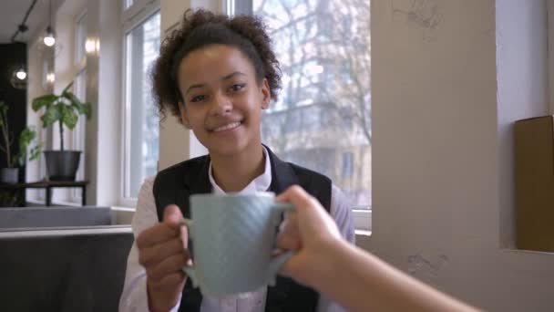 Glimlachen zwart meisje maken clink clink met kopje thee met vriend in cafe — Stockvideo