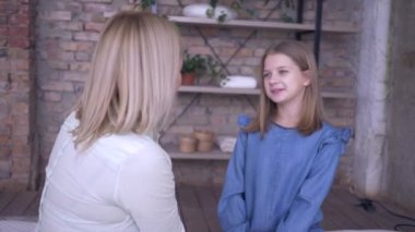 Anneye sevgiler, mutlu gülümseyen bir kız çocuğu. Annesine sarılıyor ve evde dinleniyor.