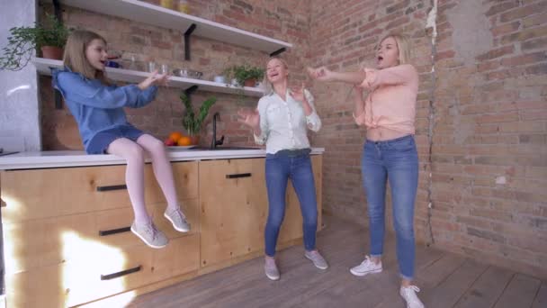 Домашняя вечеринка с мамой, веселые девочки поют с мамой и веселятся на кухне — стоковое видео