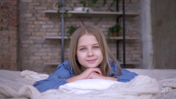 Retrato de niña encantadora con ojos azules acostado en la almohada en la cama en la habitación — Vídeo de stock