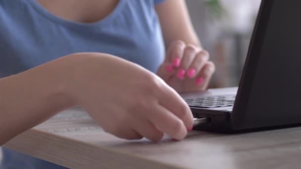 Женщина-фрилансер вставляет флэш-карту в ноутбук и печатает на клавиатуре, руки закрываются — стоковое видео