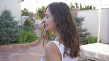 Çekici bir kadın ağaçların arasında yürüyor açık havada ve güneş ışığında uçuyor.