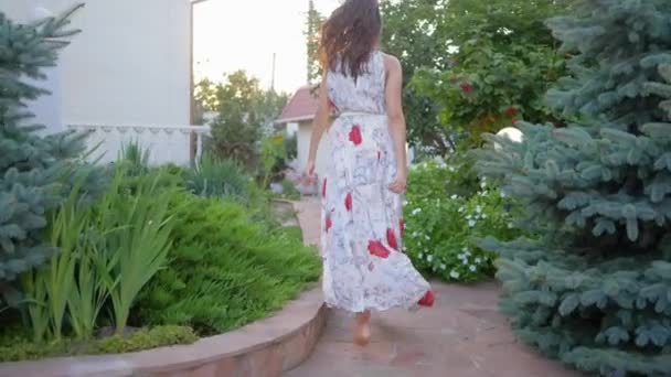 attractivité féminine, femme pieds nus en robe longue invite et court le long du chemin parmi les fleurs 