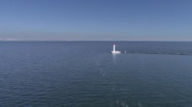 Mavi gökyüzüne karşı suyun ortasında deniz fenerinin güzel drone manzarası