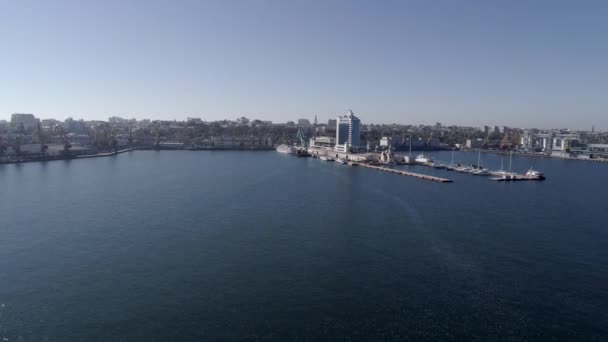 Volando sopra il porto marittimo industriale con navi portacontainer e hotel sulla costa del Mar Nero contro il cielo blu, vista dall'alto — Video Stock