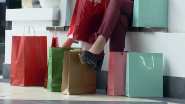 Alışverişcilik, kız arkadaşlar satın almayı düşünüyor şık ayakkabılarla bacakların yanında paketler mevsimlik satış sırasında kapanıyor.