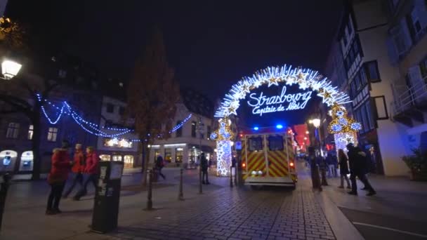 Пожарные, машины скорой помощи спешат спасать на пожарный вызов на улице в гирляндах среди ходячих в канун Рождества — стоковое видео