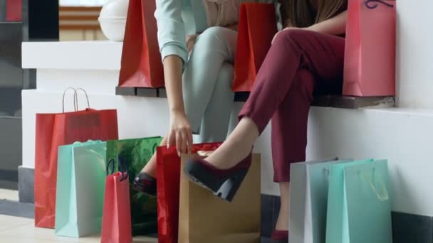 Vendas de compras, amigos do sexo feminino considerando compras em pacotes de lote perto de pernas em sapatos elegantes durante a temporada de descontos — Vídeo de Stock