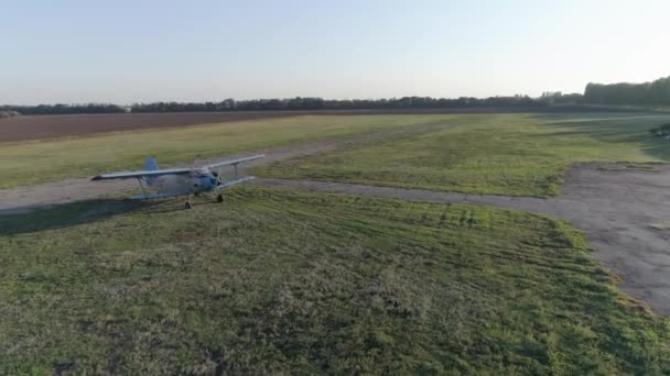 Vintage propeller vliegtuig arriveert op landingsveld op groene weide tegen blauwe lucht in zonnig weer in de lucht uitzicht — Stockvideo