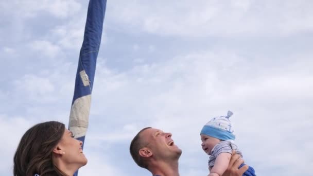 Papa wirft Sohn in die Luft, Sommerpause des glücklichen Paares mit Baby im Freien, kleines Kind in den starken Händen des Vaters — Stockvideo