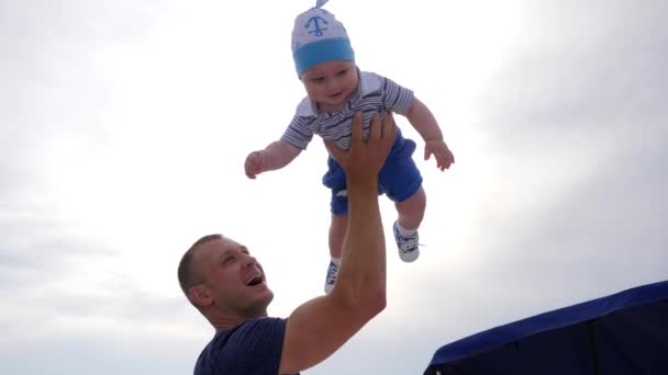 Guter Papa spielt mit Sohn im Freien, Papa zieht Baby in den Armen, kleines Kind in Vätern starken Händen im Sonnenlicht, — Stockvideo
