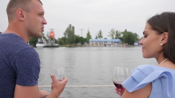 Romantik çift denizde kırmızı içecek içer, tatilde iki kişi, ellerinde bardak, arkadan erkek ve kadın görüşü. — Stok video