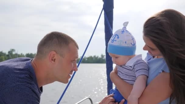 Bom humor da família amigável em férias para o rio, jovem mãe e pai brincaram com o bebê no mar em barco , — Vídeo de Stock