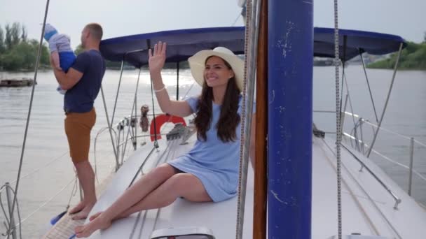 손을 흔들며 인사하는 여자, 좋은 아빠, 즐거운 배에서 아들을 돌보는 여름 방학아름다운 여자 가족 과 함께 — 비디오