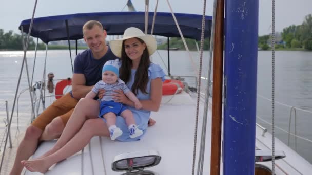 Vacances de couple heureux avec bébé au yacht à voile en mer, portrait de famille heureuse reposant en bateau sur le lac, voyage en famille — Video