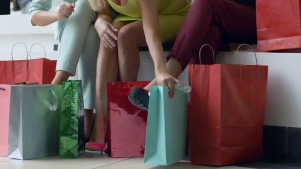 Εποχή των εκπτώσεων, η γυναίκα της εταιρείας εξετάζει ψώνια σε τσάντες κοντά στα πόδια σε ζωντανά παπούτσια κοντά κατά τη διάρκεια της εποχιακής πώλησης — Αρχείο Βίντεο
