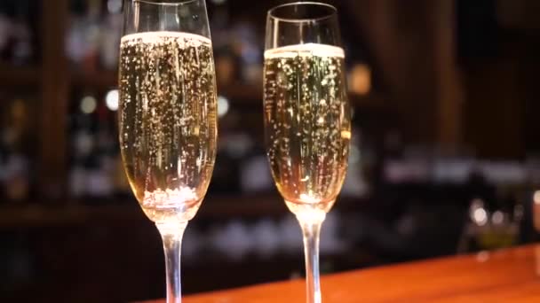 Copa de vino con bebida alcohólica con burbujas sobre fondo desenfocado — Vídeos de Stock