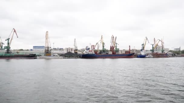 Vista do mar no porto de comércio da cidade com navios de carga, guindastes e grandes elevadores de grãos no fundo do mar — Vídeo de Stock